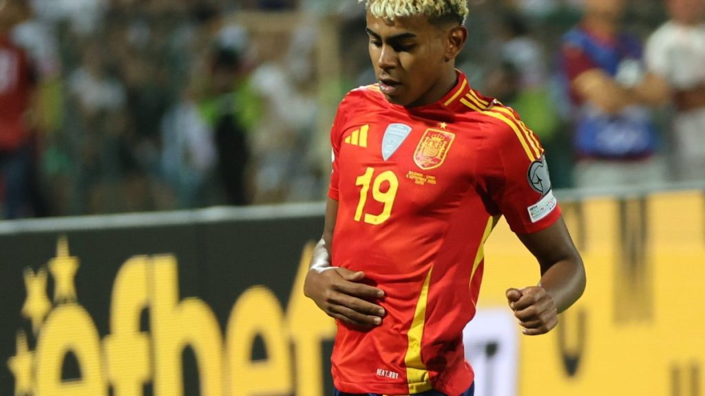Lamine Yamal conduce el balón con la camiseta de España durante un partido internacional