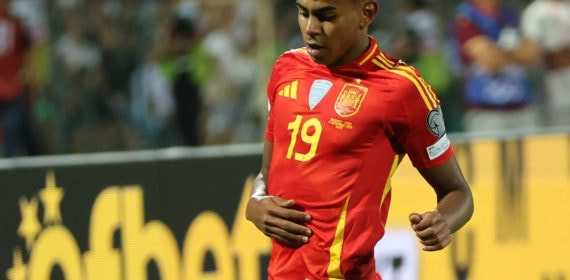 Lamine Yamal conduce el balón con la camiseta de España durante un partido internacional