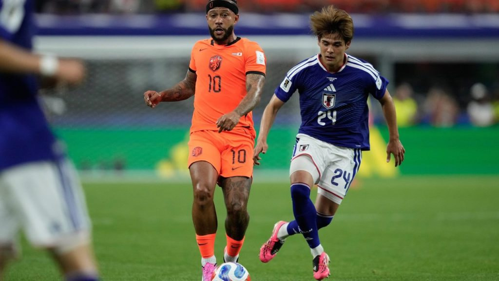 Memphis Depay juega el balón ante la marca de Kaishu Sano en un partido del Mundial 2026.