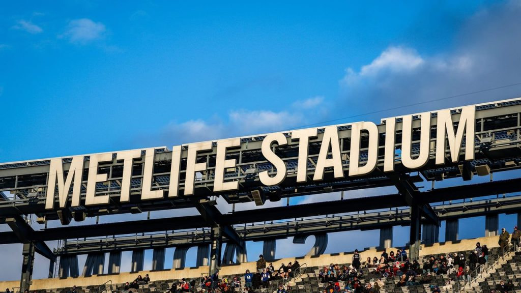 Letras con el nombre del MetLife Stadium sobre las gradas del estadio durante un evento deportivo.