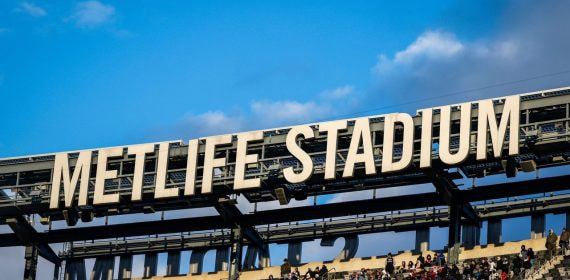 Letras con el nombre del MetLife Stadium sobre las gradas del estadio durante un evento deportivo.