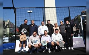 Jugadores y directivos de pádel posan con sus palas en una pista montada junto al Obelisco de Buenos Aires