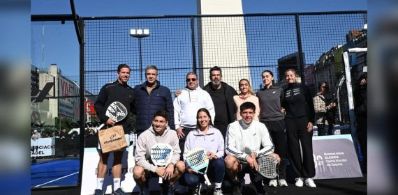 Jugadores y directivos de pádel posan con sus palas en una pista montada junto al Obelisco de Buenos Aires