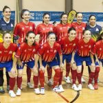 Las jugadoras de un equipo de fútbol sala femenino posan para la foto de equipo en la pista