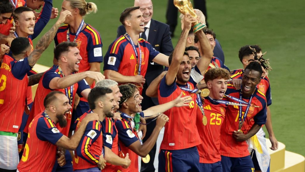 El capitán de España, Rodrigo Hernández, levanta al cielo del MetLife Stadium la Copa del Mundo rodeado de sus compañeros de selección.