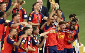 El capitán de España, Rodrigo Hernández, levanta al cielo del MetLife Stadium la Copa del Mundo rodeado de sus compañeros de selección.