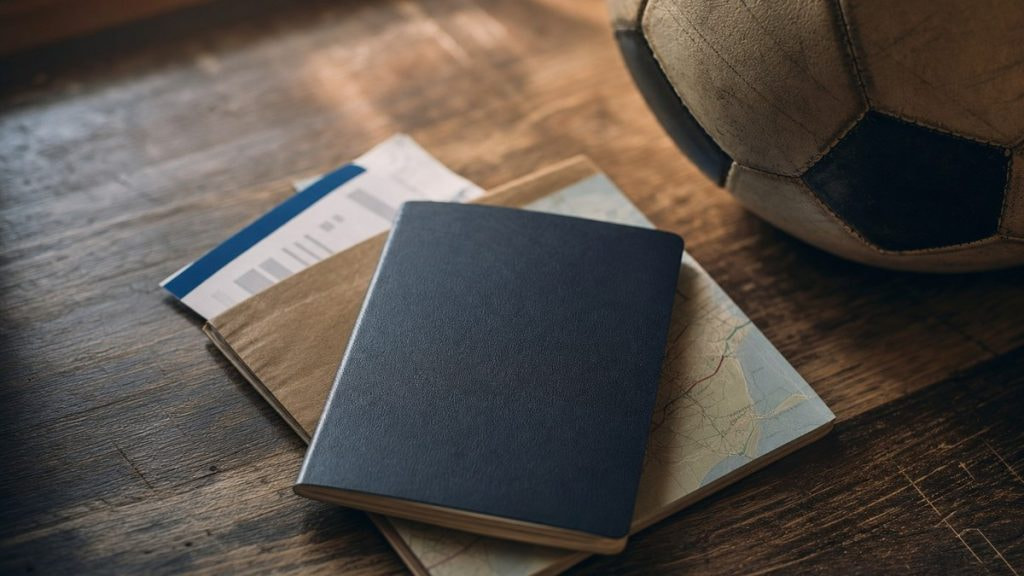 Pasaporte, tarjeta de embarque y un balón de fútbol sobre una mesa de madera, listos para viajar al Mundial 2026
