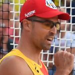 Adrián Gavira, con gorra roja y camiseta de España, aprieta el puño para celebrar un punto en la arena.