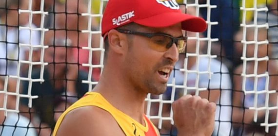 Adrián Gavira, con gorra roja y camiseta de España, aprieta el puño para celebrar un punto en la arena.