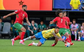 Bruno Guimarães cae al césped disputando el balón ante dos rivales de Marruecos en el Mundial 2026.