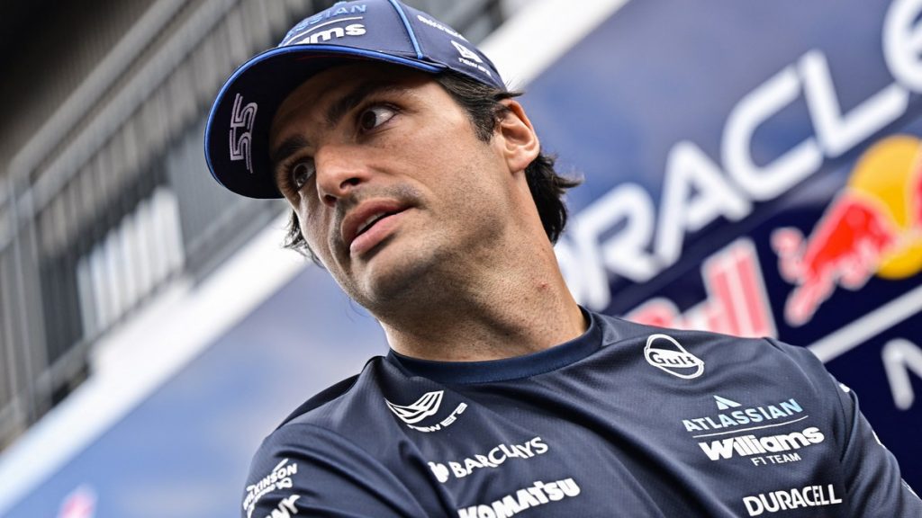 Carlos Sainz mira hacia un lado con la gorra y el polo de Williams en el paddock del Hungaroring.
