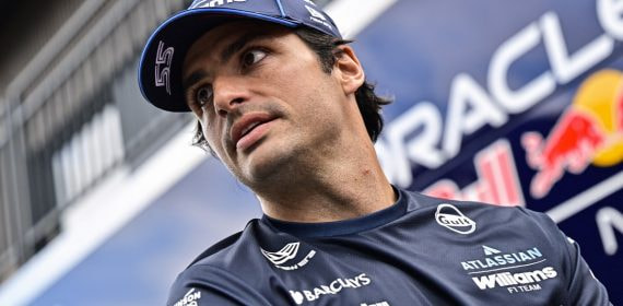 Carlos Sainz mira hacia un lado con la gorra y el polo de Williams en el paddock del Hungaroring.