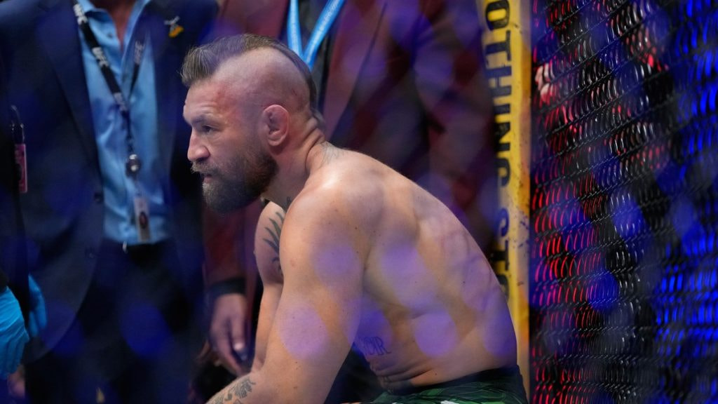 Conor McGregor reacciona sentado en el octógono tras perder ante Max Holloway en el UFC 329 de Las Vegas
