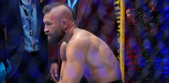 Conor McGregor reacciona sentado en el octógono tras perder ante Max Holloway en el UFC 329 de Las Vegas