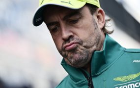 Fernando Alonso, con la equipación de Aston Martin, baja la mirada con gesto de resignación.
