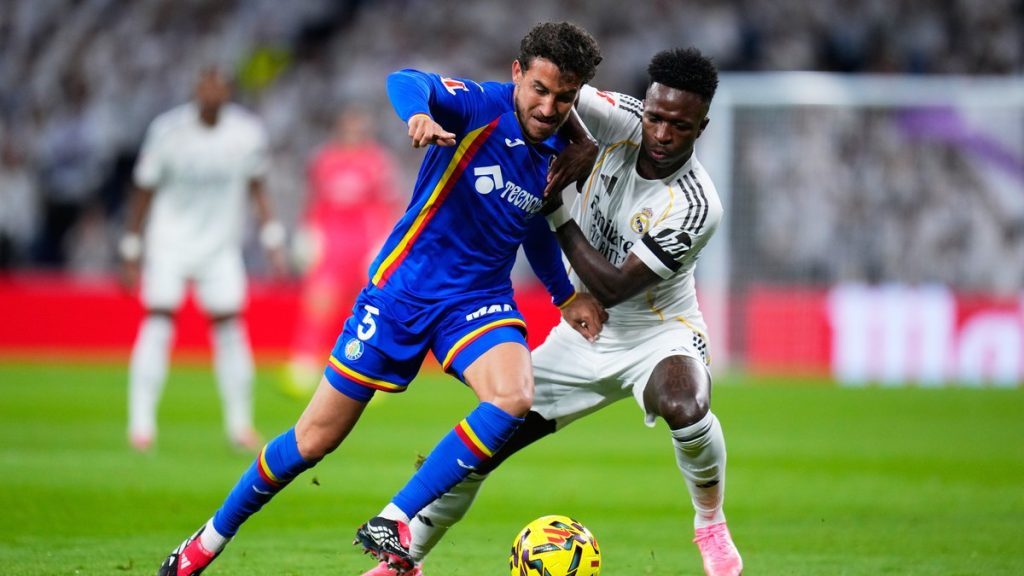 Luis Milla, del Getafe, pugna por el balón con Vinícius Júnior durante un partido de LaLiga en Madrid