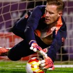 Marc-André ter Stegen se estira para blocar un balón a ras de césped junto al poste de su portería