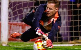 Marc-André ter Stegen se estira para blocar un balón a ras de césped junto al poste de su portería