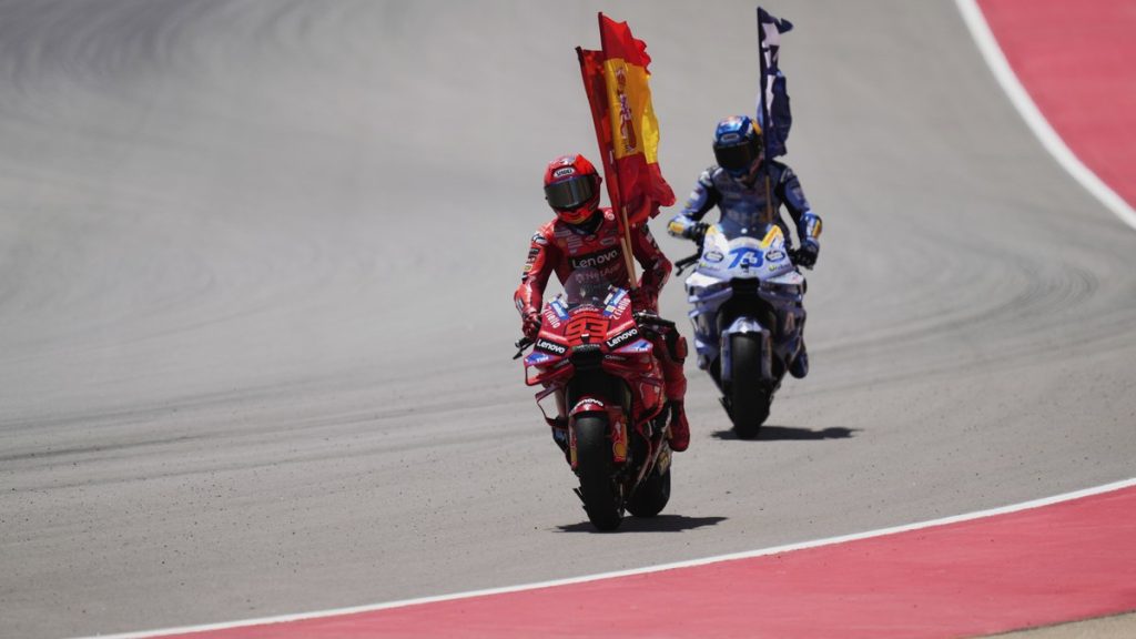 Marc Márquez y Álex Márquez celebran con banderas sobre sus motos tras la carrera del GP de Aragón