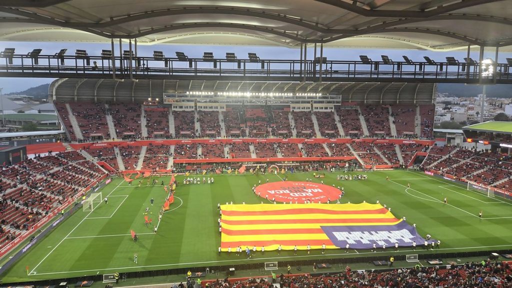 Las gradas de Son Moix, llenas al atardecer, con la senyera balear desplegada sobre el césped.