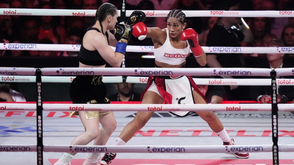 Amanda Serrano golpea a Katie Taylor durante el segundo asalto de su combate por el título del superligero en Nueva York