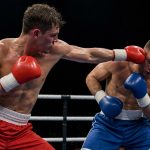 Dos púgiles intercambian golpes en el centro del ring durante un combate profesional