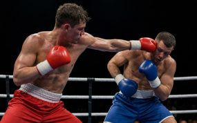 Dos púgiles intercambian golpes en el centro del ring durante un combate profesional