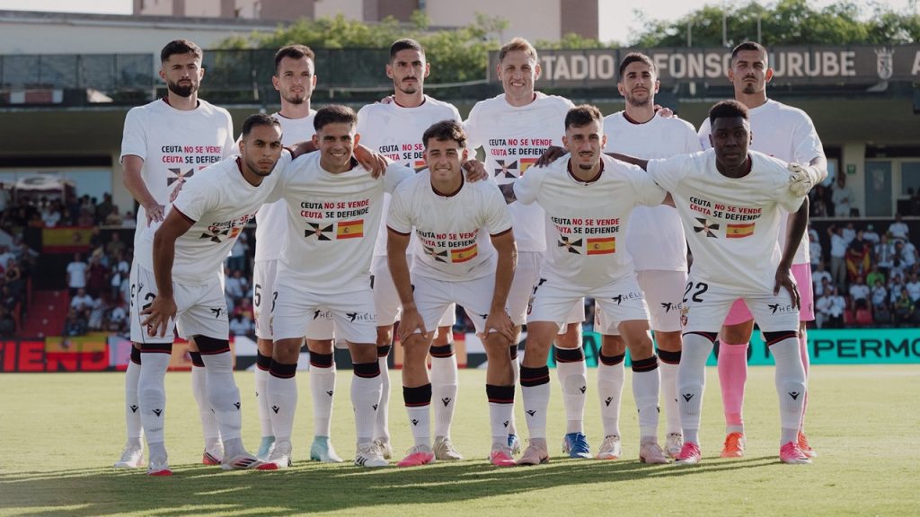 El once titular de la AD Ceuta luce unas camisetas con el lema 'Ceuta no se vende, Ceuta se defiende' justo antes del partido del equipo ante la UD Las Palmas.