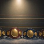 Cuatro cinturones de campeón alineados sobre la lona de un ring de boxeo vacío