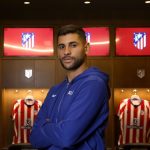 Cristian 'Cuti' Romero posa con los brazos cruzados en el vestuario del Atlético de Madrid, ante las camisetas colgadas