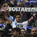 Un aficionado del Dépor exhibe una bandera con el lema 'Voltaremos' durante un partido de su equipo.