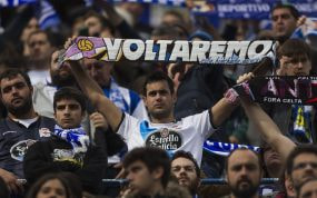 Un aficionado del Dépor exhibe una bandera con el lema 'Voltaremos' durante un partido de su equipo.