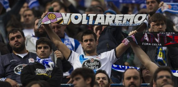 Un aficionado del Dépor exhibe una bandera con el lema 'Voltaremos' durante un partido de su equipo.