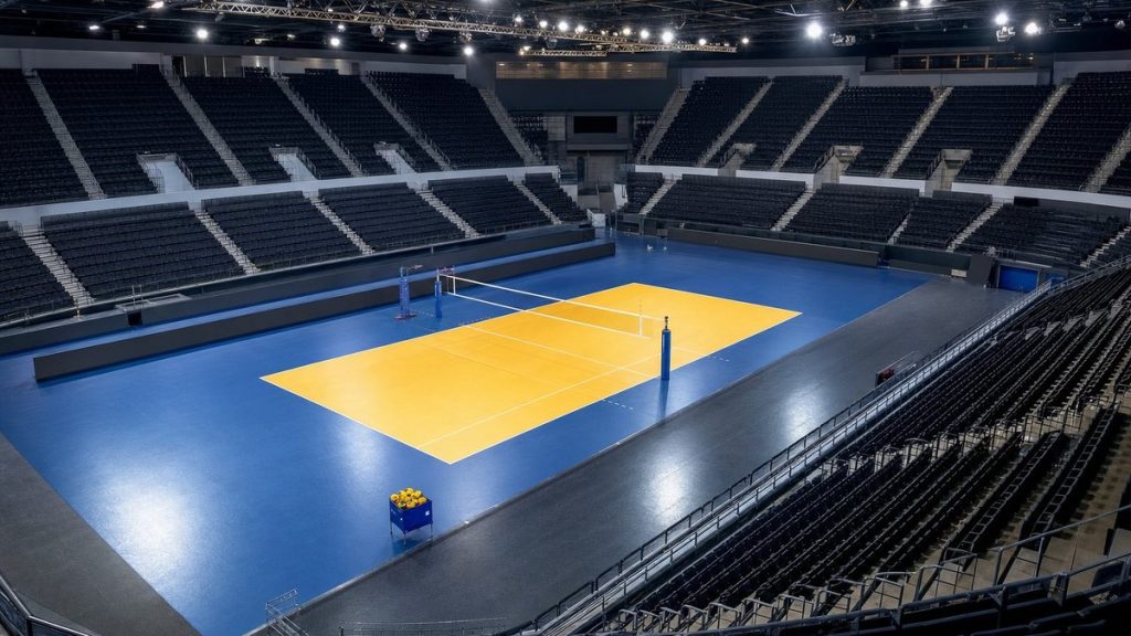 Pista de voleibol iluminada y vacía en un pabellón antes de un partido