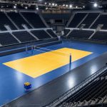 Pista de voleibol iluminada y vacía en un pabellón antes de un partido