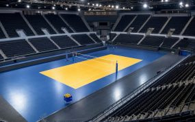 Pista de voleibol iluminada y vacía en un pabellón antes de un partido