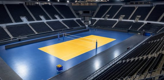 Pista de voleibol iluminada y vacía en un pabellón antes de un partido