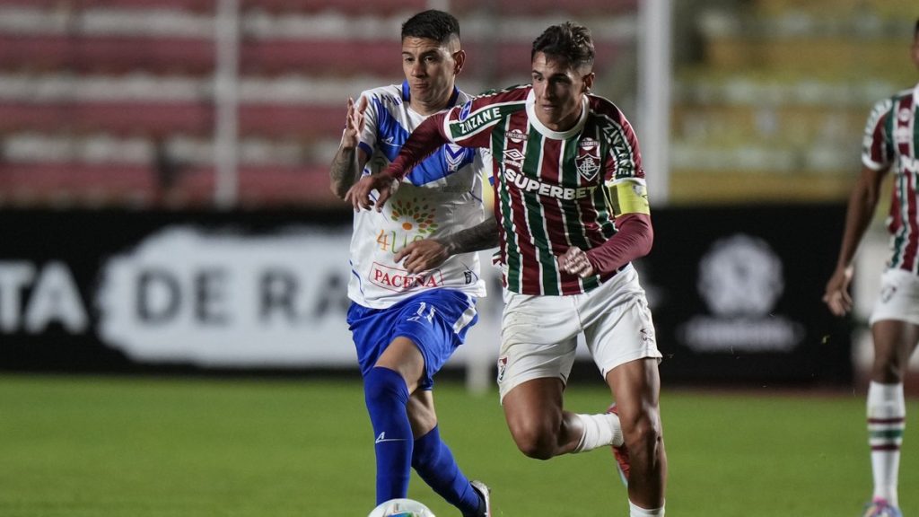 Facundo Bernal avanza con la camiseta del Fluminense perseguido por un rival del GV San José