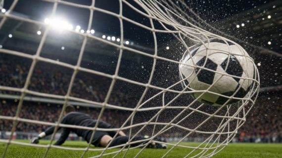 Balón cruzando la línea de gol y golpeando la red en un estadio de fútbol iluminado de noche