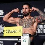Ilia Topuria flexiona los brazos sobre la báscula durante el pesaje oficial del UFC Freedom 250