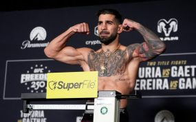 Ilia Topuria flexiona los brazos sobre la báscula durante el pesaje oficial del UFC Freedom 250