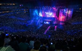Público llenando un pabellón durante una final de esports, con las pantallas del escenario iluminadas
