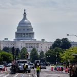 Operarios y maquinaria asfaltan una avenida de Washington con el Capitolio al fondo