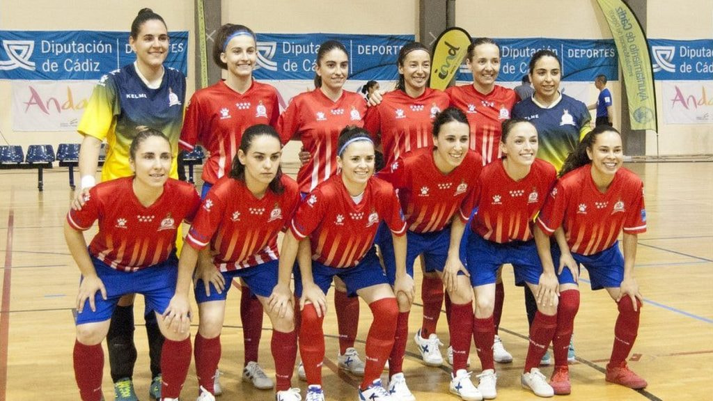 Las jugadoras de un equipo de fútbol sala femenino posan para la foto de equipo en la pista