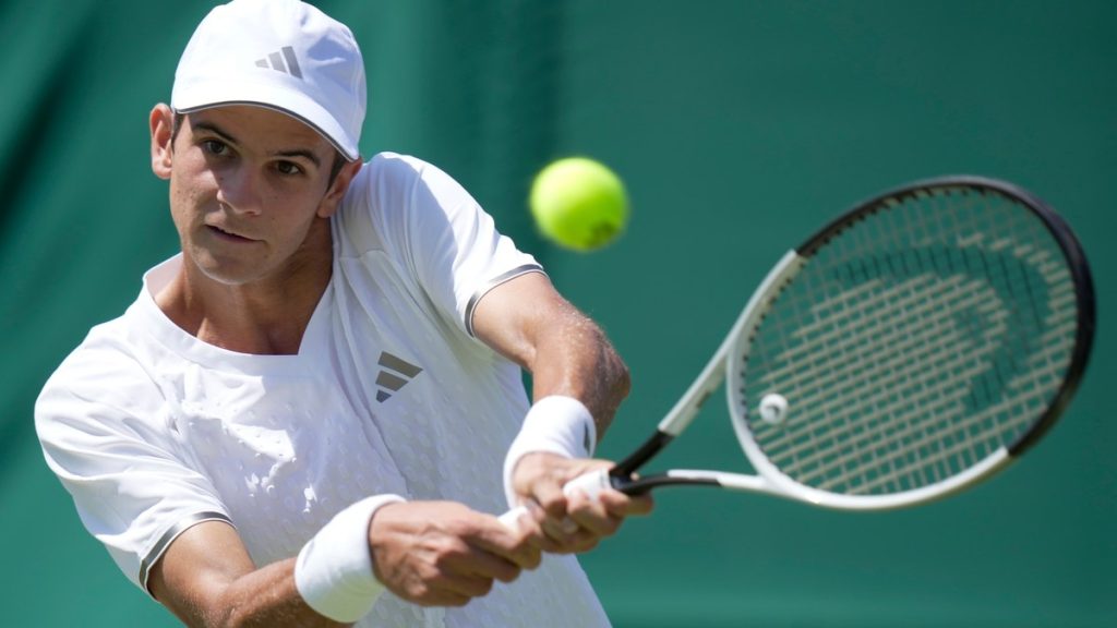 Rafa Jódar golpea un revés a dos manos vestido de blanco durante un partido sobre hierba