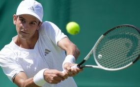 Rafa Jódar golpea un revés a dos manos vestido de blanco durante un partido sobre hierba