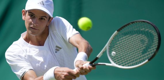 Rafa Jódar golpea un revés a dos manos vestido de blanco durante un partido sobre hierba