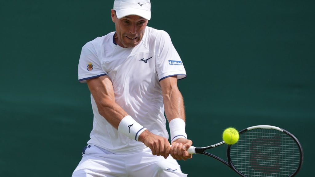 Roberto Bautista Agut golpea un revés a dos manos durante su partido de primera ronda en Wimbledon 2026