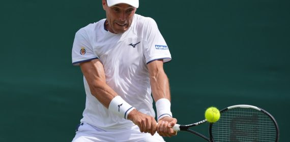 Roberto Bautista Agut golpea un revés a dos manos durante su partido de primera ronda en Wimbledon 2026