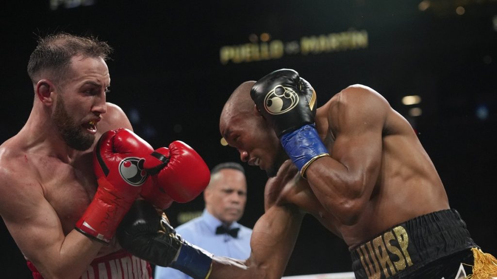 Sandor Martín encaja un golpe de Alberto Puello durante el noveno asalto de su combate por el título WBC del superligero en Nueva York